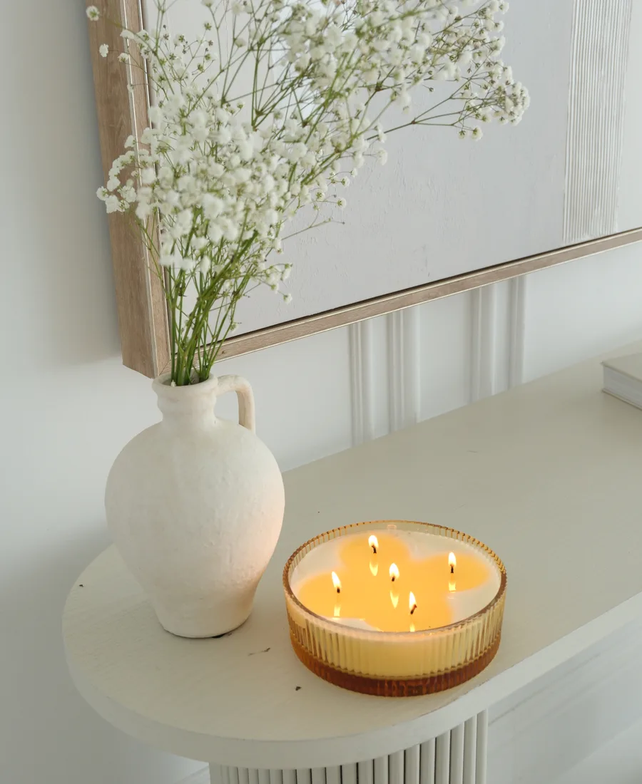 Vela encendida y flores blancas sobre mesa — ambiente de calma y meditación